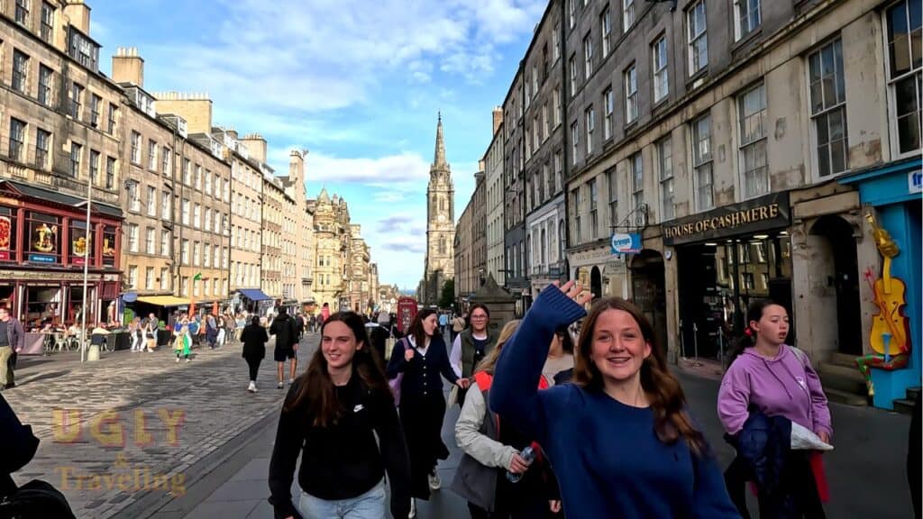 Vibrant street scene in Edinburgh with students and historic architecture on a sunny day.