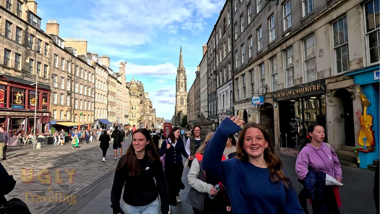 Vibrant street scene in Edinburgh with students and historic architecture on a sunny day.