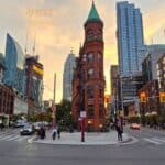 Historic red brick building in downtown urban city skyline at sunset.